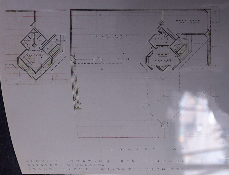   
An architectural blueprint of Frank Lloyd Wright’s service station design shows a symmetrical floor plan labeled with spaces including Rest Room, Lav, Pay, Office, Store Room, and Work Area. The drawing features Wright’s geometric layout style and is titled “Service Station for Lindholm Oil Co., Cloquet, Minnesota — Frank Lloyd Wright, Architect.”