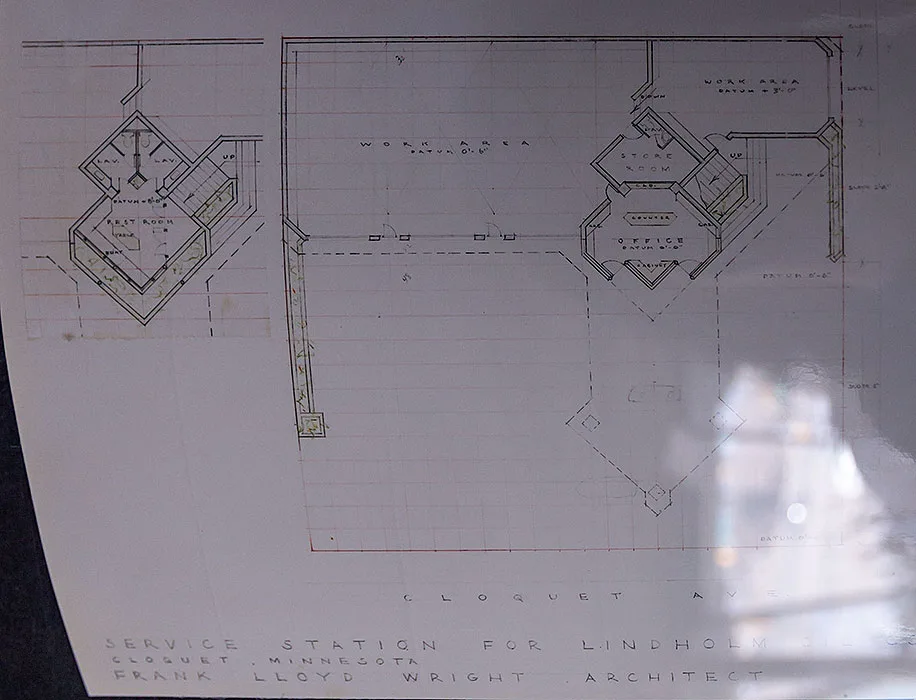   
An architectural blueprint of Frank Lloyd Wright’s service station design shows a symmetrical floor plan labeled with spaces including Rest Room, Lav, Pay, Office, Store Room, and Work Area. The drawing features Wright’s geometric layout style and is titled “Service Station for Lindholm Oil Co., Cloquet, Minnesota — Frank Lloyd Wright, Architect.”