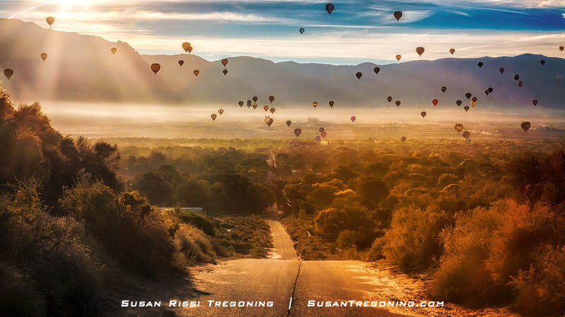 The sun’s harsh glare rises over the majestic Sandia Mountains as colorful balloons float over Corrales, New Mexico, during the Albuquerque International Balloon Fiesta.