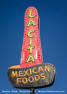 A vintage roadside sign shaped like a large red sombrero with a black brim, reading “La Cita” and “Mexican Foods” in yellow letters. The sign, originally installed in 1944, stands against a clear blue sky.