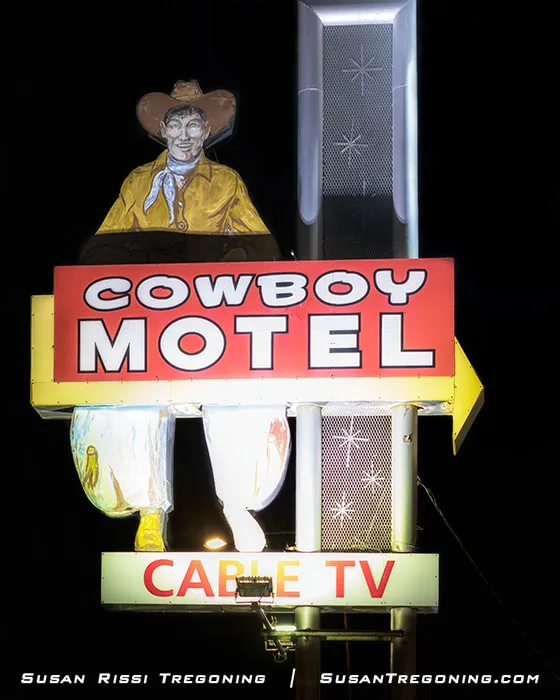 A large 1963 cowboy‑shaped motel sign at the Cowboy Motel in Amarillo, Texas, with its former neon tubing removed and bulb holes filled, standing as a vintage roadside landmark along Route 66.