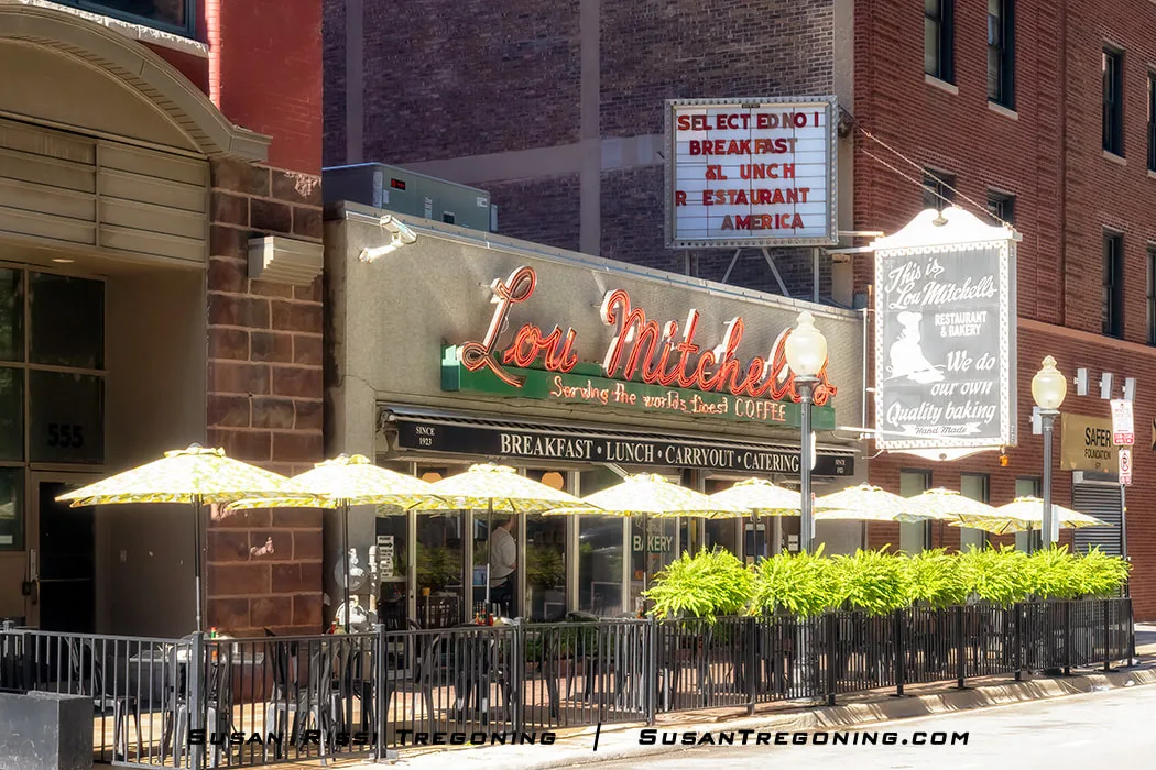 Exterior of Lou Mitchell’s Restaurant on Jackson Boulevard in Chicago with vintage signage, outdoor seating, and surrounding downtown buildings.