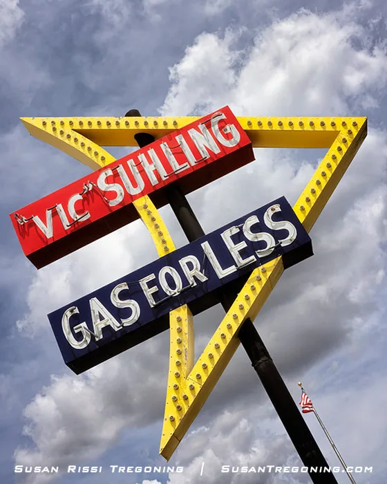 The Vic Suhling / Gas for Less neon sign stands beside the Litchfield Museum and Route 66 Welcome Center on historic Route 66. The sign features yellow, red, and black coloring.