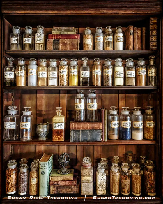 A pharmacy showcase inside the Deck’s Pharmacy Museum at Doc’s Just Off 66 displays old patient medicines and remedies. Bottles, containers, and period pharmacy items are arranged inside the case.