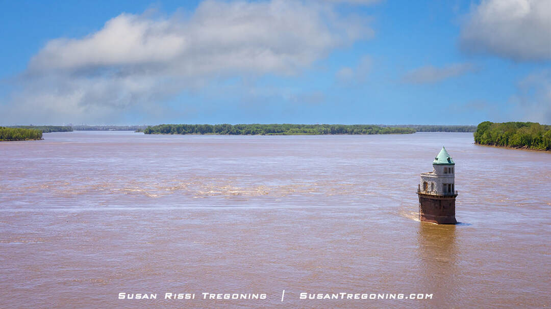 A view of the St. Louis pumping station intake tower #1 from the Old Chain of Rocks Bridge, standing in the middle of the Mississippi River at the Chain of Rocks, with the St. Louis skyline faintly visible in the distance.