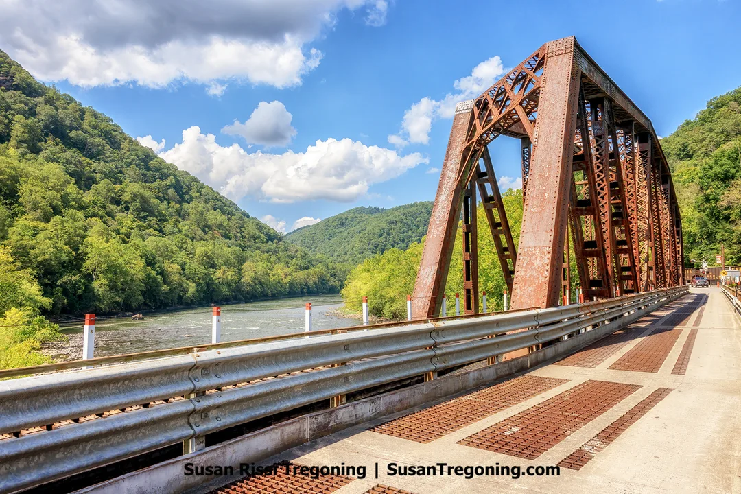 Alt text: View of the New River seen through the railroad truss section of the Thurmond Railroad Bridge while walking toward Thurmond in New River Gorge National Park.
