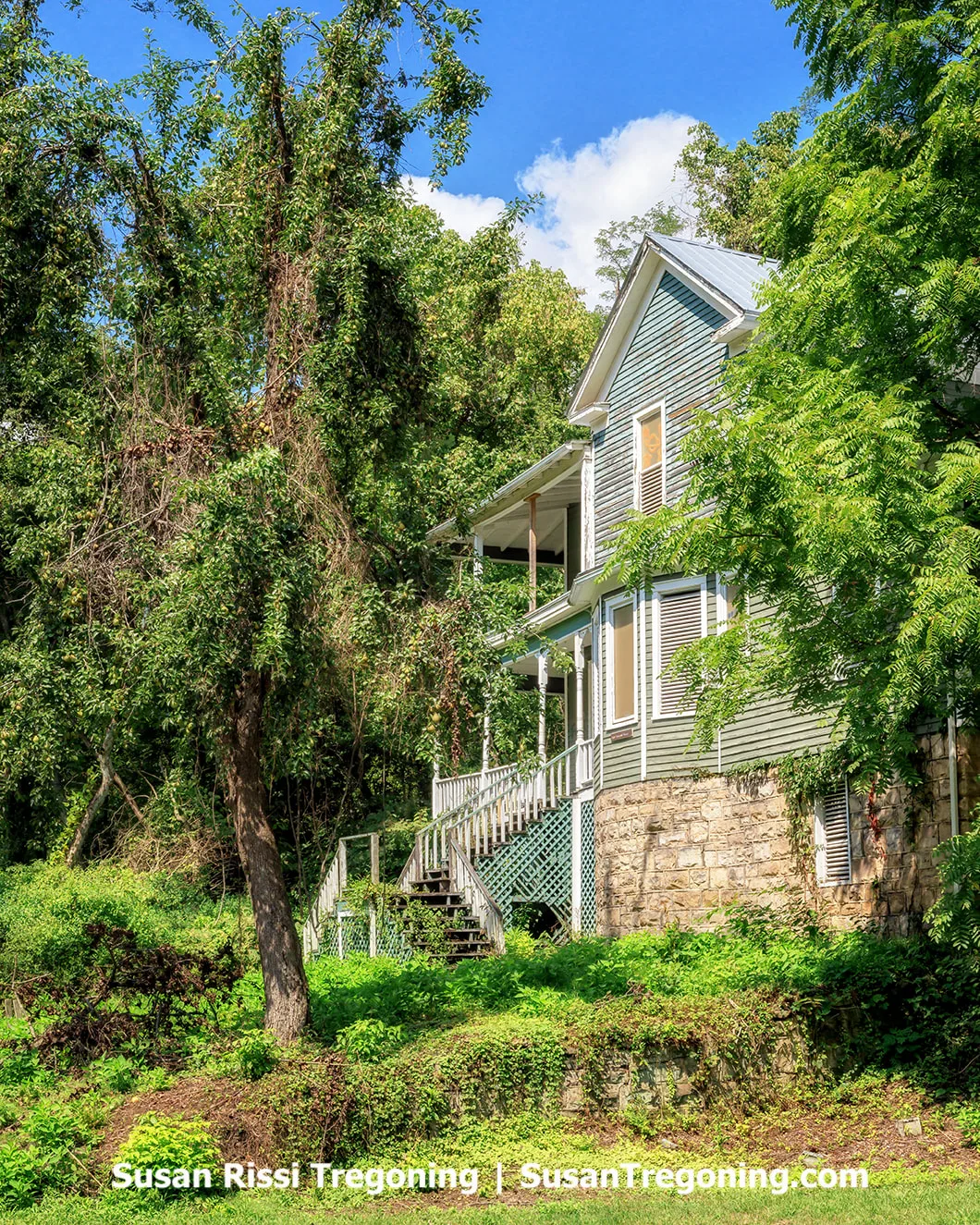 A large historic house built around 1900, known as Fatty Lipcomb’s Guest House, standing on the floodplain at the west end of Thurmond. The two‑story structure sits in front of the railroad tracks at the base of the mountain and is one of the few remaining historic homes in town.