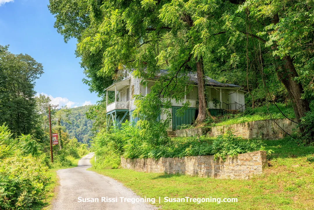 A basic one‑story, four‑room house built before 1920, known as the James Humphery Sr. House, standing on a partly exposed, fully enclosed basement supported on stilts, giving the structure a two‑story appearance on the mountainside above Thurmond.
