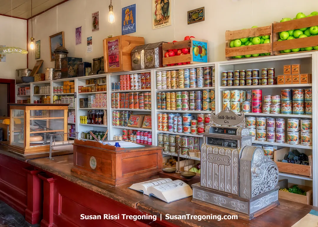 Interior view of the Smith‑Sherlock Company Store in South Pass City, showing shelves, counters, and period merchandise arranged inside the preserved wooden building. The space reflects the late‑nineteenth‑century mercantile business operated by Janet Sherlock and James Smith, whose family ran the store until 1948.