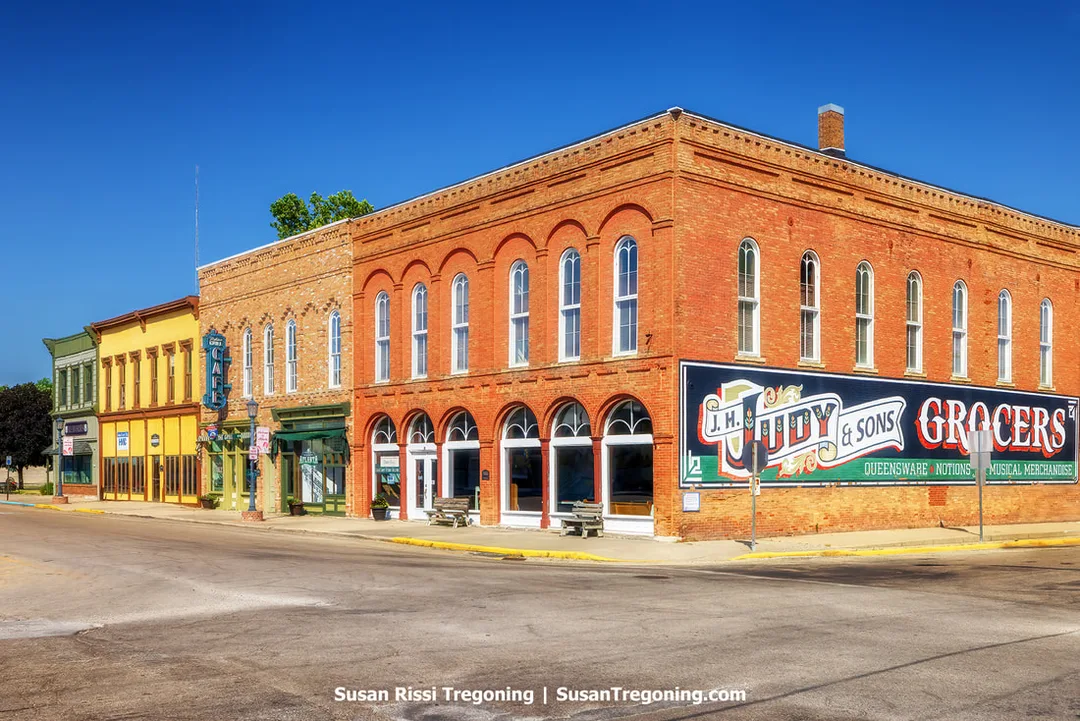  The Downey Building, an Italianate‑style structure in the center of the downtown business district in Atlanta, Illinois, stands along historic Route 66. The building once housed the Palms Grill Café during Route 66’s peak years and is the oldest standing building in Atlanta. Next to it is the former grocery store building with the J.H. Judy & Sons Grocers mural painted on its side.