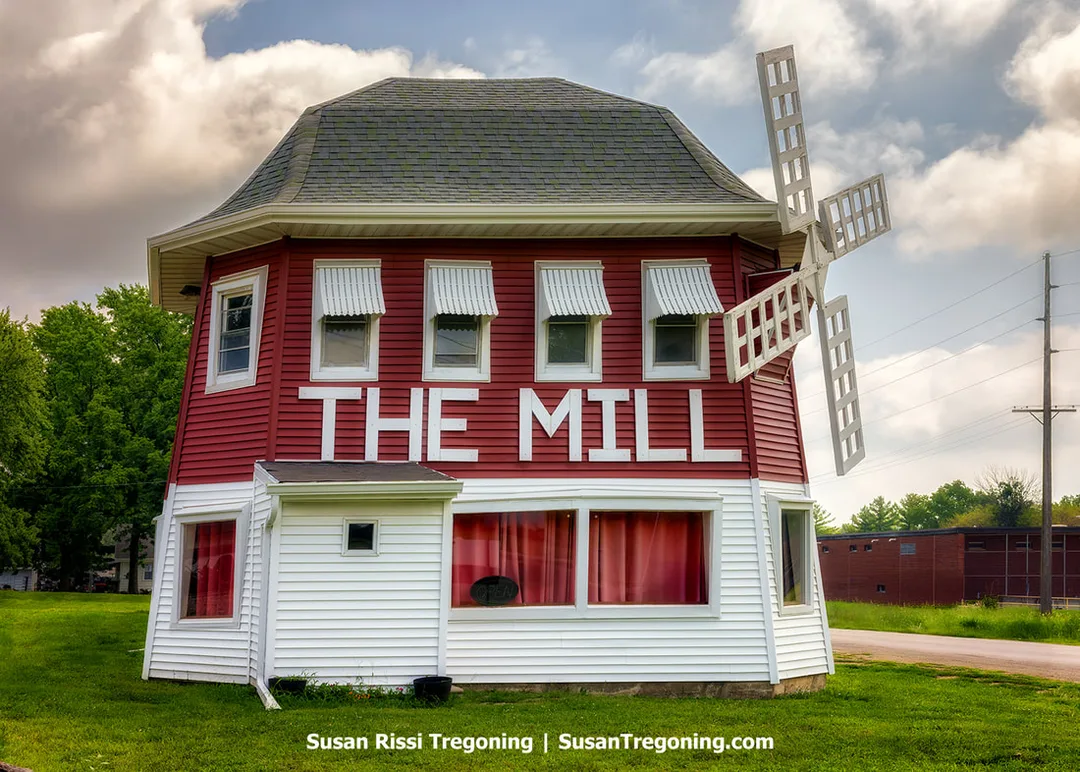The Mill on 66 Museum in Lincoln, Illinois, stands on the original 1929 alignment of Route 66. The red and white Dutch‑themed building features mill‑style architecture with a windmill structure on the exterior. The museum occupies the site of the former Blue Mill restaurant, which opened in 1929 on Route 4 before the road became the 1930–1940 alignment of Route 66.