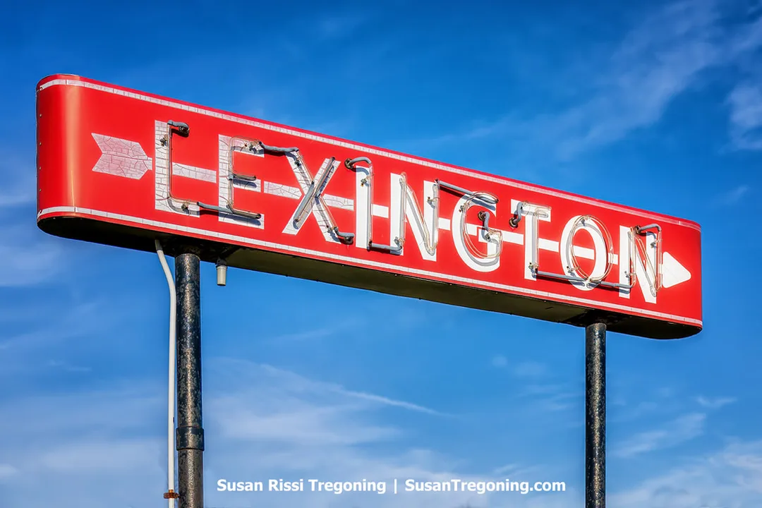 The original red Lexington Arrow neon sign on a blue sky points visitors toward downtown Lexington.