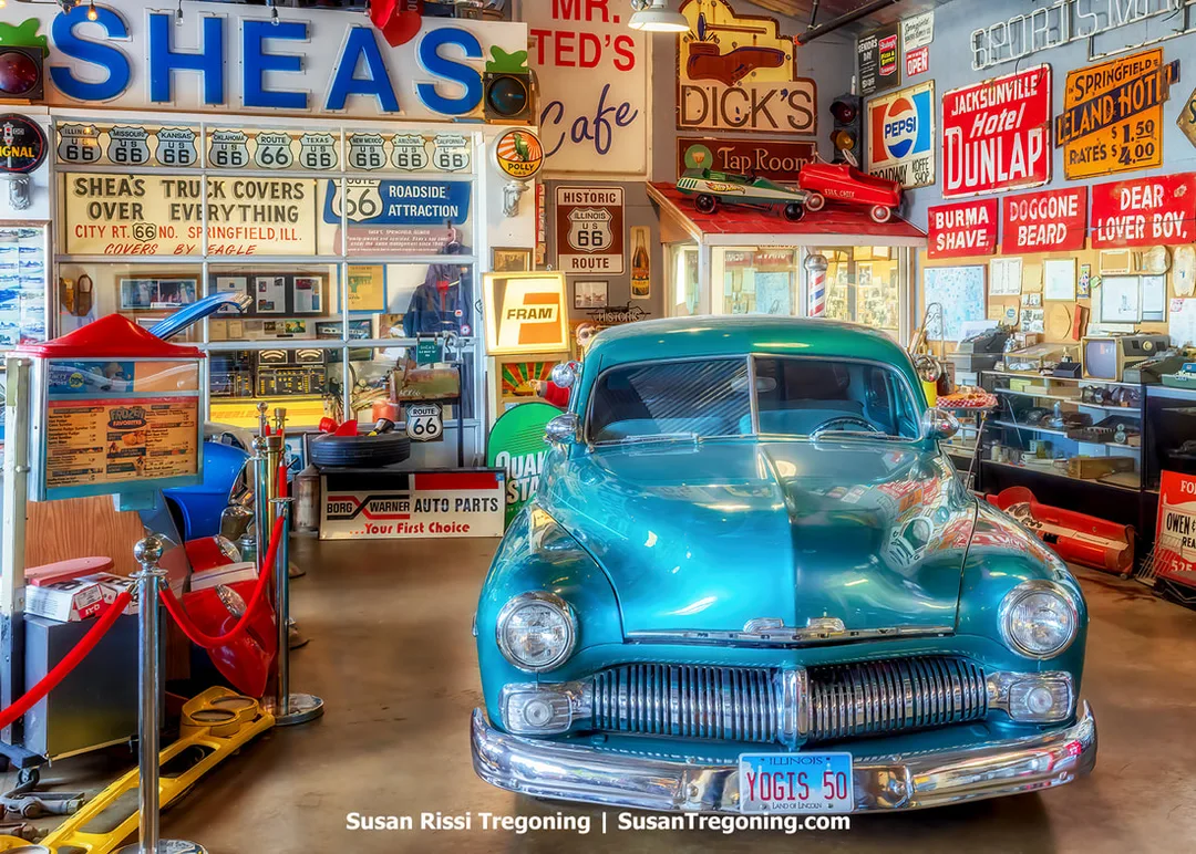 A 1950 Mercury Coupe is on display inside the Motorheads Museum at Motorheads Bar & Grill in Springfield, Illinois. The car is surrounded by Historic Route 66 memorabilia and additional automotive displays.