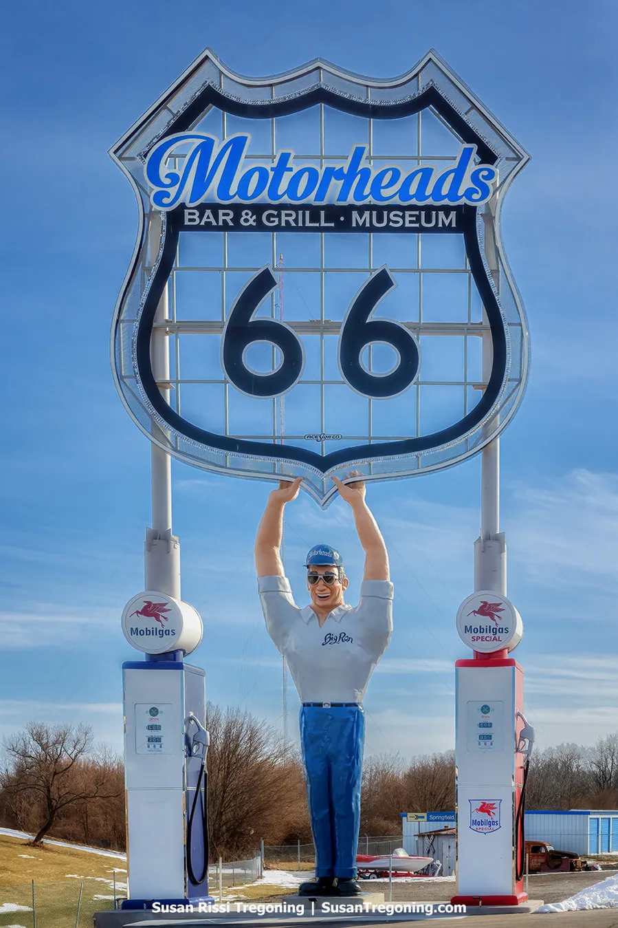 The Big Ron giant stands at Motorheads Bar, Grill, and Museum in Springfield, Illinois. The figure is flanked by two large Mobilgas tanks and holds up what is described as the largest Route 66 shield on the Mother Road. 