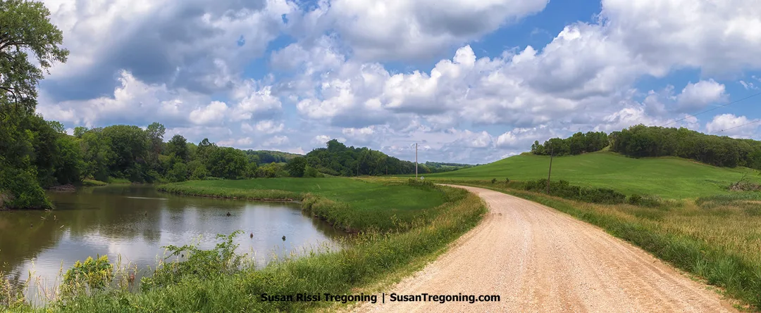 A view along the Preparation Loop showing the Soldier River Cutoff beside a gravel road. The scene includes the waterway running near the roadside within the Loess Hills landscape.