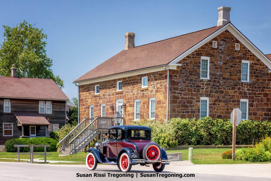 A Ford Model A cruises by the historic Schwalbe Kitchen and Conquest Home as the Iowa Model A Car Show concludes in Amana, Iowa.