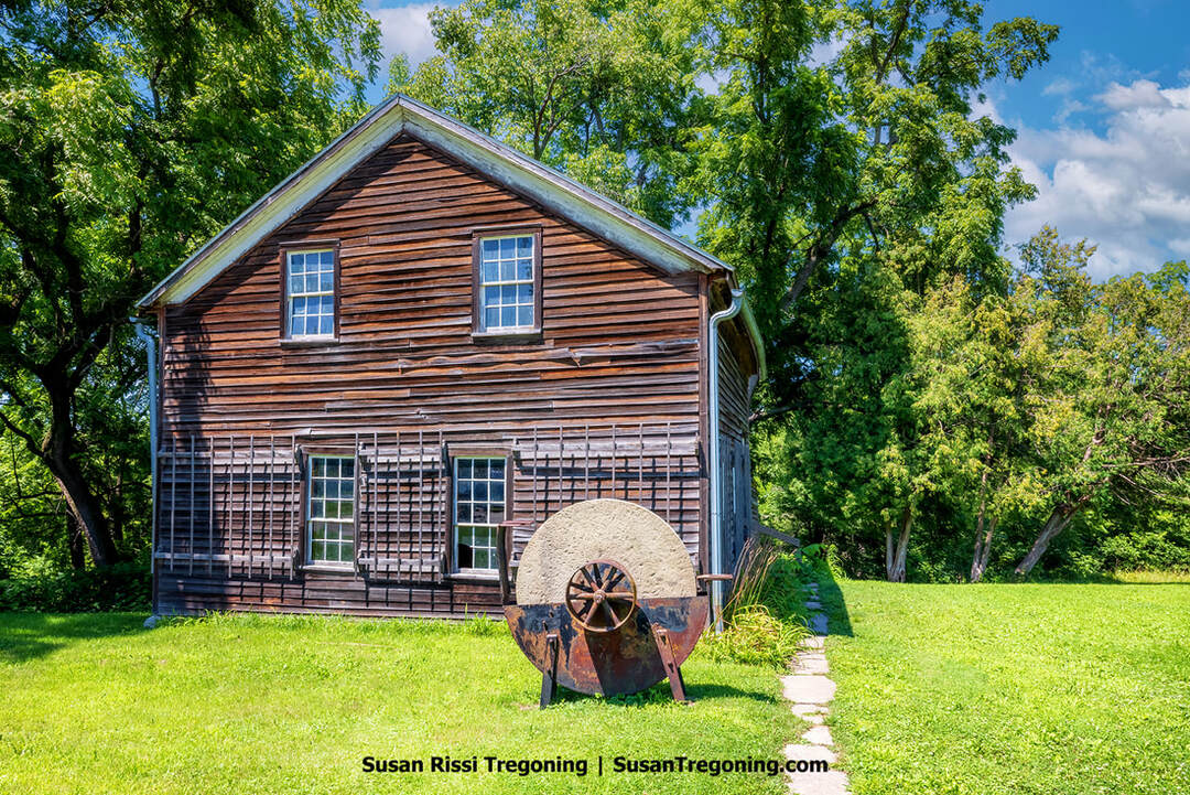 The exterior of the Amana Copper Shop, showing a simple historic building with traditional Amana architectural details. The view includes its windows and siding, reflecting the long‑standing copper‑working tradition of the Amana Colonies.