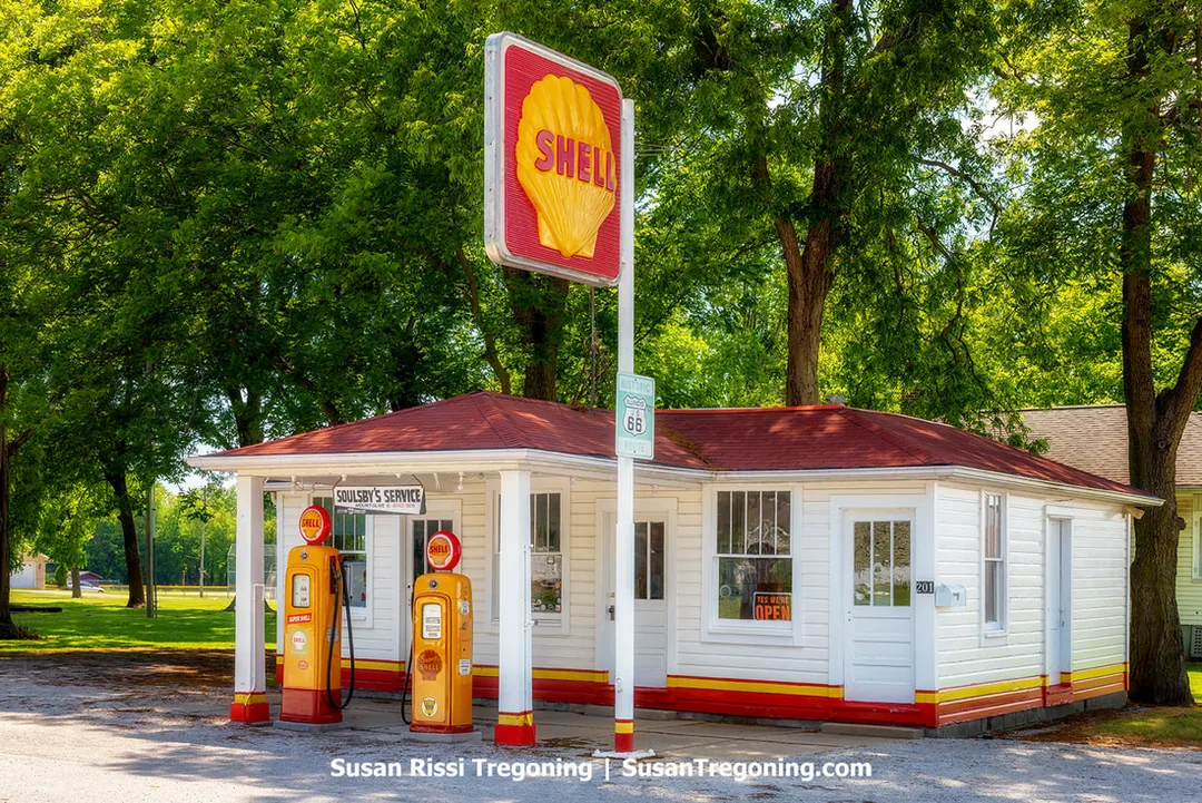 Soulsby Service Station in Illinois is shown from the exterior. The white building features gold and red Shell branding and is recognized as the oldest gas station still in usable condition on the Illinois section of Route 66.