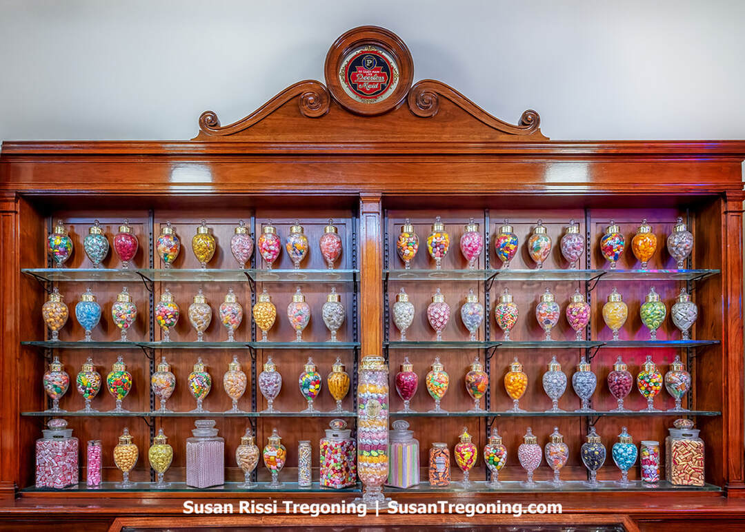 A vintage Peerless candy display inside Schimpff’s Candy Museum features rows of old‑fashioned candy jars, colorful boxed sweets, and historic packaging arranged on shelves. The exhibit recreates the look of an early‑20th‑century confectionery counter, highlighting the Peerless brand’s local candy‑making history.