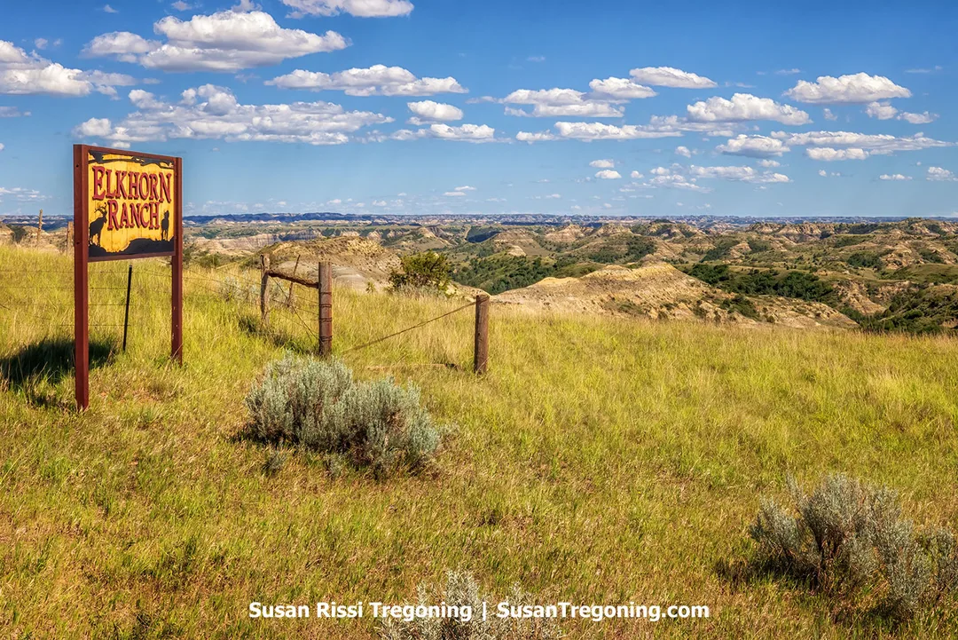 An old wooden sign reading “Elkhorn Ranch” stands on a grassy hill overlooking the rugged Badlands of western North Dakota. This spot marks the entrance to the Forest Service’s Elkhorn Ranchlands, part of the historic landscape where Theodore Roosevelt once ranched before establishing his conservation legacy.