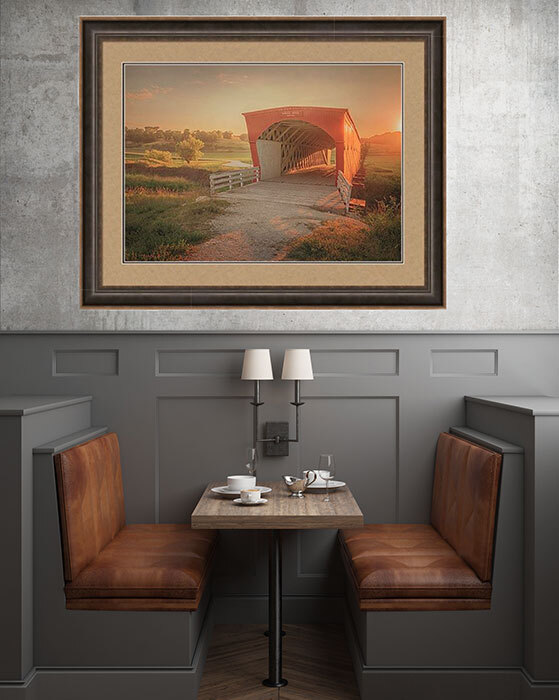 A sunset view of the Hogback Covered Bridge anchors the space, its rich reds and golden light complementing the café’s leather seating and soft wall lighting.