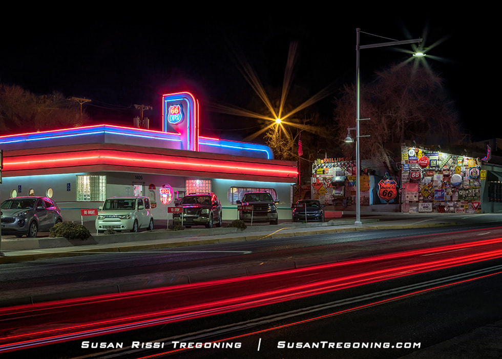 Car tail lights streak past in this night shot of the 66 Diner aglow with colorful neon on Route 66 AKA Central Avenue in Alburquerque, New Mexico.