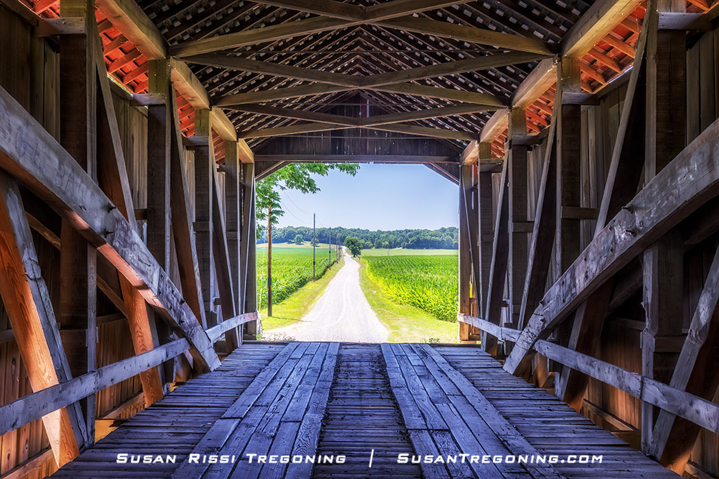 Standing inside the McAllister Covered Bridge in Parke County, Indiana, looking out at the country lane and cornfields is a cool escape from the midday summer heat. Parke County, with 31 covered bridges, is known as the “Covered Bridge Capitol of the World.”